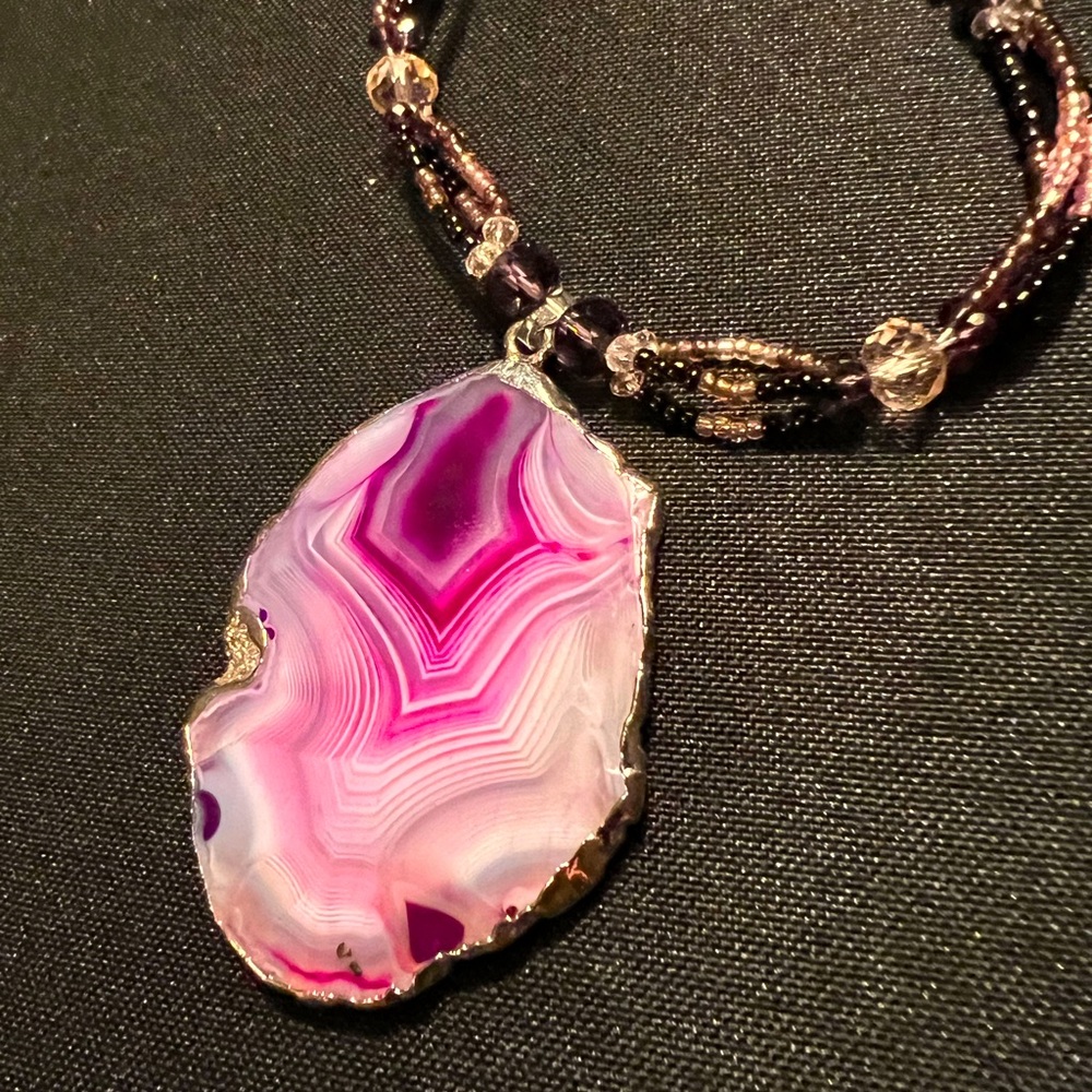 Beaded necklace with mixed purple stone. Clasp closure